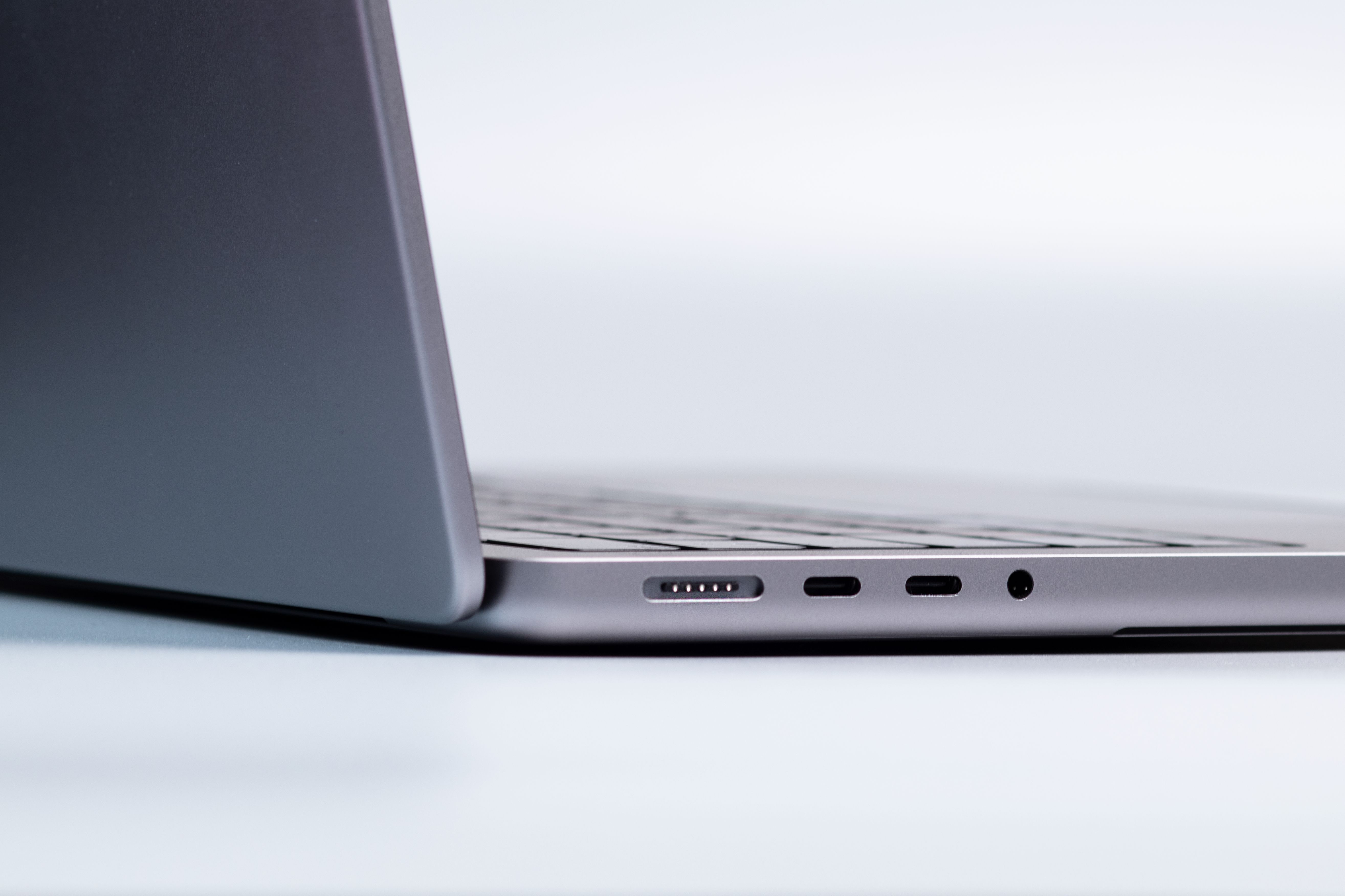 Close-up of a laptop's side ports, showing Thunderbolt/USB-C connectors and headphone jack.